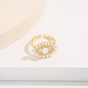 Detail of gold evil eye ring featuring a center pearl and micro-inlaid zircon crystals