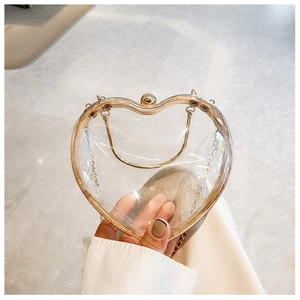 Detailed close-up of a clear acrylic heart-shaped bag with a gold metal frame and chain