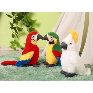 Three colorful plush parrot toys in red, green and white on a soft green carpet