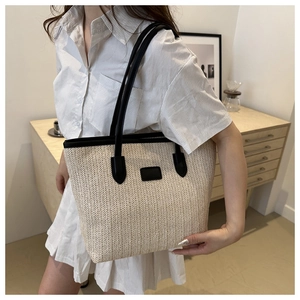 Chic woven straw tote bag in cream white and black leather handles for summer fashion