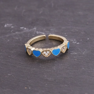 Gold open ring with blue enamel hearts and white crystals on grey stone base