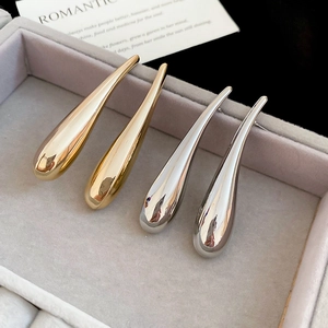 Detail of gold and silver teardrop earrings with mirror finish in a jewelry box