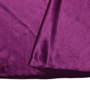 Detail of purple satin fabric texture with smooth glossy finish and stitched hemline