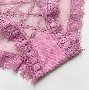 Macro de culotte en dentelle rose avec lanières croisées et texture mesh à pois