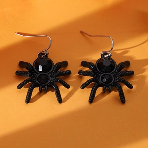 Gothic black spider earrings with faceted stones for Halloween on orange background