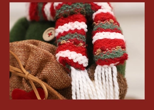 Macro detail of knitted scarf and burlap bag with red heart on a Christmas doll