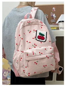 Zaino in velluto a coste rosa con ricamo a ciliegia indossato da modella per la taglia
