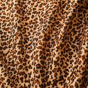 Close-up of soft satin scarf with leopard print and elegant gold foil metallic details