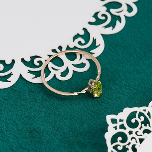 Macro view of French vintage S925 ring with oval olive green gemstone and twisted rose gold band