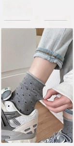 Detailed view of grey polka dot crew socks with elastic stretch on cotton fabric