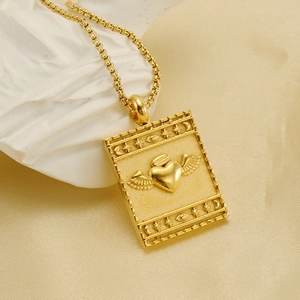 Golden rectangular heart pendant necklace with wings and mystical symbols on stone