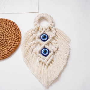 Close-up of handmade macrame leaf wall hanging with blue evil eye beads decor