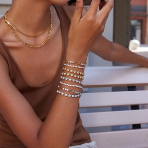 Detail of luxury gold and silver stainless steel tennis bracelets with white zircon stones