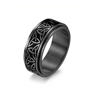 Detailed close-up of a black titanium spinner ring featuring Celtic triquetra patterns