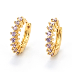 Detailed view of 18K gold plated huggie earrings featuring prong-set purple zircons