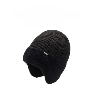 Détail du bonnet en tricot noir avec doublure en fausse fourrure et étiquette FBXS