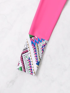 Détail des manches rose fluo avec motifs géométriques colorés sur le maillot de bain sport