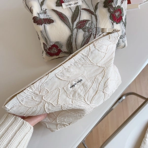 Close-up of floral embroidery and quilted fabric texture on cotton handbag set