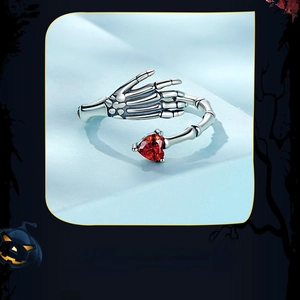 Detailed macro shot of gothic skull hand ring with a vibrant red heart gemstone