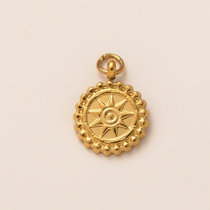Detailed close-up of 18K gold-plated circular pendant with engraved sun and beaded edge