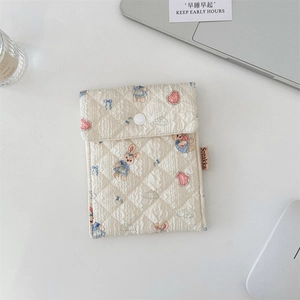 Detailansicht der gesteppten beigen Tasche mit süßen Kaninchen-Mustern und Stoffhaptik