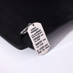 Polished stainless steel dog tag keychain with engraved inspirational quotes on a black base
