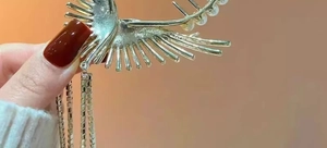 Close-up of golden tassel hair claw with elegant pearl inlay and fine metal chain detail