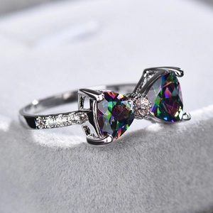 Macro shot of silver bow ring featuring rainbow mystic topaz and white zircon accents