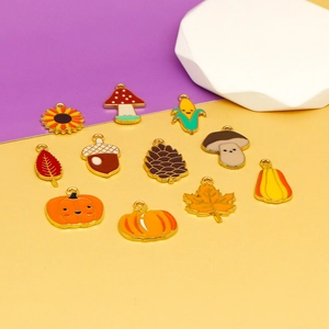 Detailed macro shot of enamel autumn charms featuring pumpkins, leaves and acorns