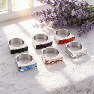 Detail of square glass crystal rings in multiple colors displayed on elegant white lace fabric
