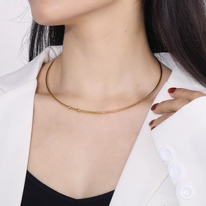 Collier ras du cou en forme de C en acier doré minimaliste porté par un mannequin élégant