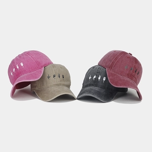Detailed view of four vintage washed baseball caps in pink, khaki, charcoal, and red