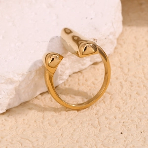 Detailed close-up of 18K gold plated stainless steel open ring on a stone