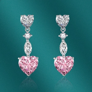 Orecchini a pendente con zircone rosa a cuore in finitura argento su sfondo verde