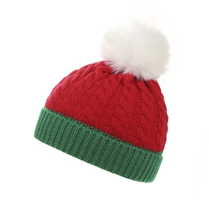 Cappello di Natale a maglia rosso e verde per bambini con un morbido pompon bianco.