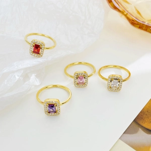 Set of four gold-plated rings with rectangular colored zircon stones and micro-pave crystals