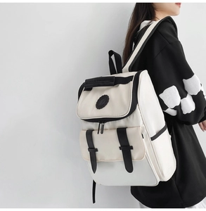 Side view of cream and black large capacity backpack worn by a model for a casual look