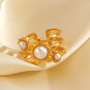 Golden irregular multi-layer open ring with three white pearls on beige silk background