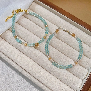 Detail of minimalist 2mm light blue faceted crystal beaded bracelets with gold and silver clasps