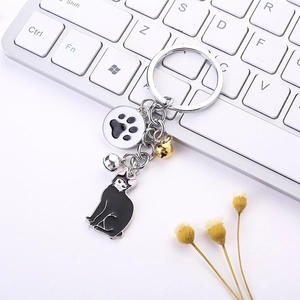 Close-up of metal cat keychain with black enamel cat charm and colorful bells