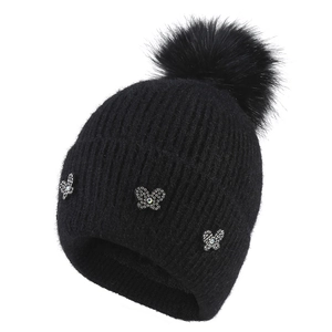 Thick black rib-knit winter beanie for women featuring a faux fur pompom and butterfly rhinestones