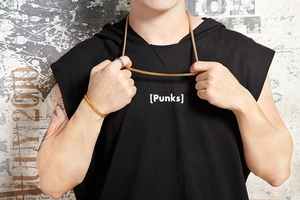 Close-up of golden stainless steel chain necklace and bracelet set worn by a male model