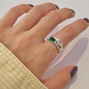 Close-up of double-layer geometric ring featuring emerald and white zircon stones