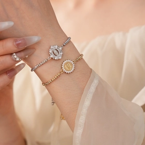 Gros plan de bracelets en or et argent avec pendentifs embossés et zircons brillants