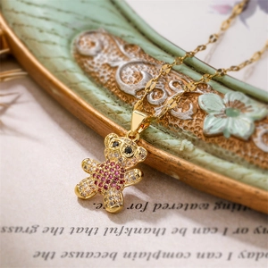 Macro shot of gold bear pendant with colorful pavé cubic zirconia on script paper