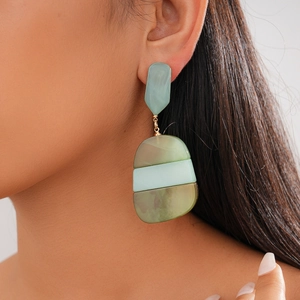 Close-up of bohemian acetate geometric earrings in mint green with marble texture