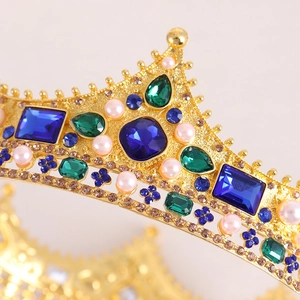 Detailed view of Baroque queen crown with blue crystals, green gems and pink pearls