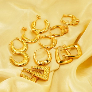Collection of golden hoop earrings featuring twisted and textured designs on satin