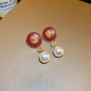 Vintage gold lion head pearl earrings with red enamel and diamond accents
