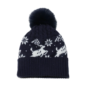 Detailed knit pattern of a navy winter beanie featuring reindeer and snowflake motifs